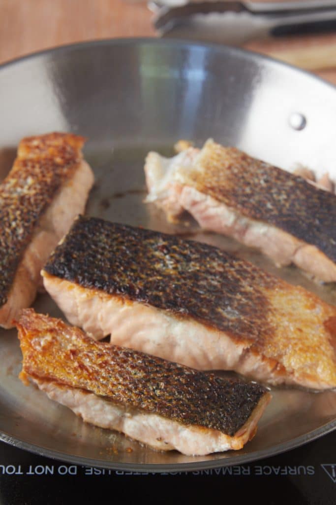 Cooking the salmon in the pan skin side up.