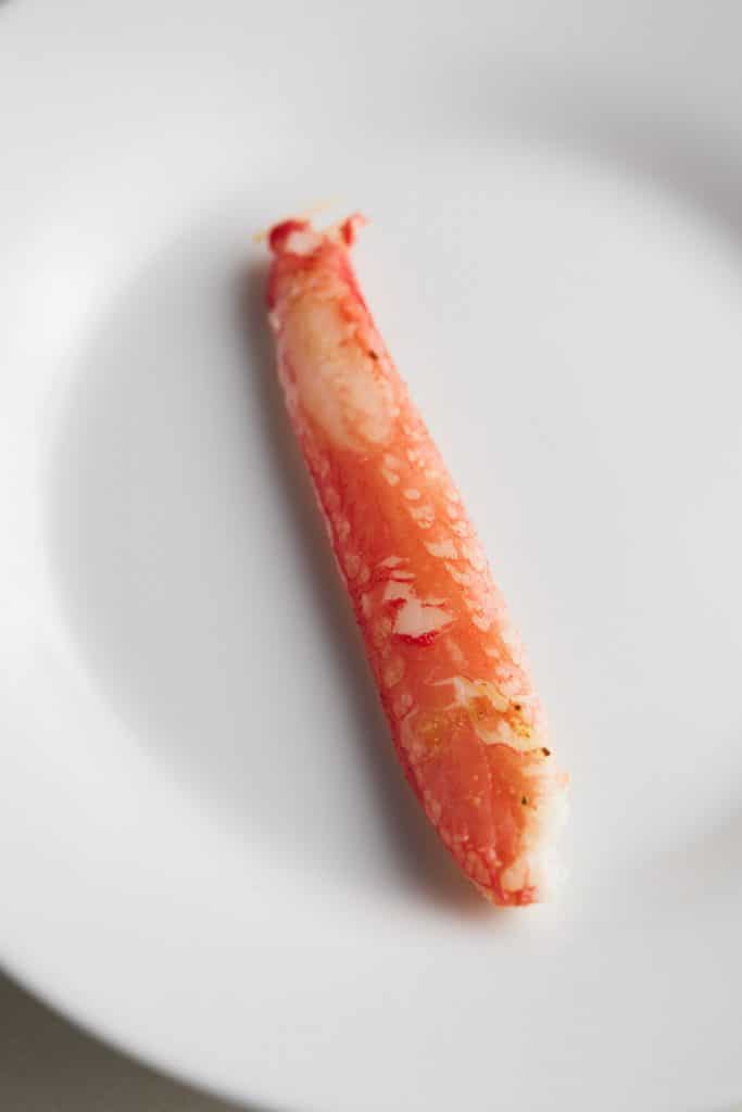A crab leg on a white plate.