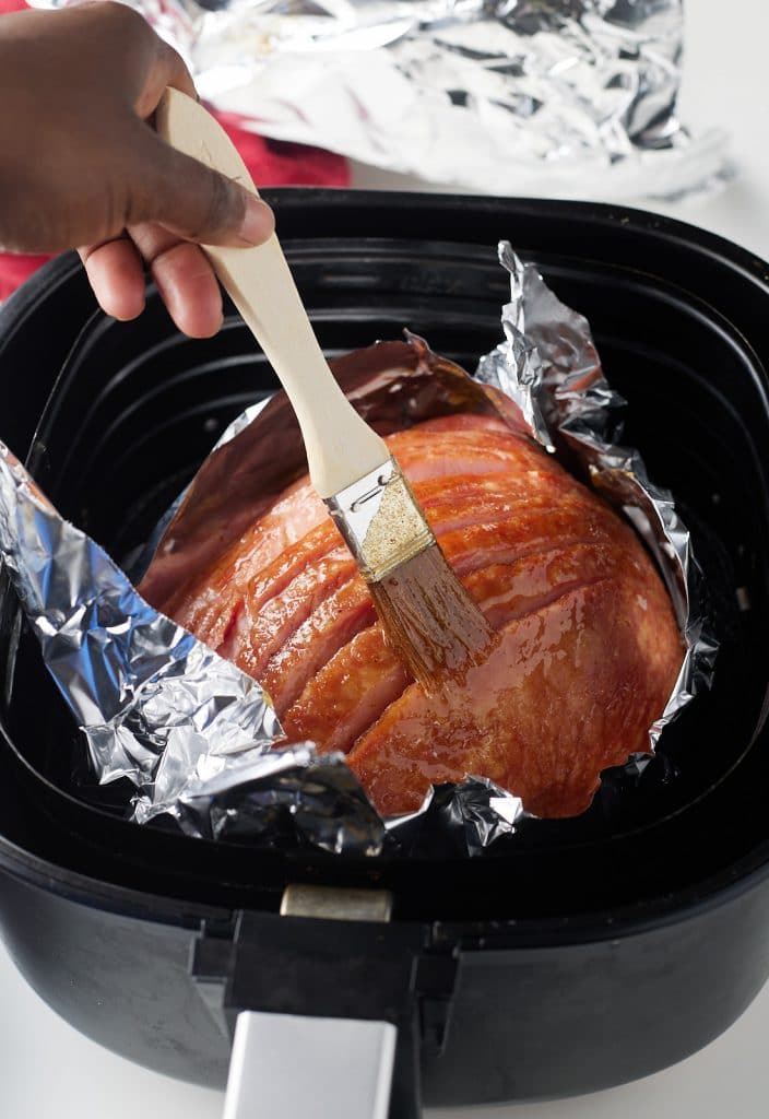 Brushing the glaze on the ham.
