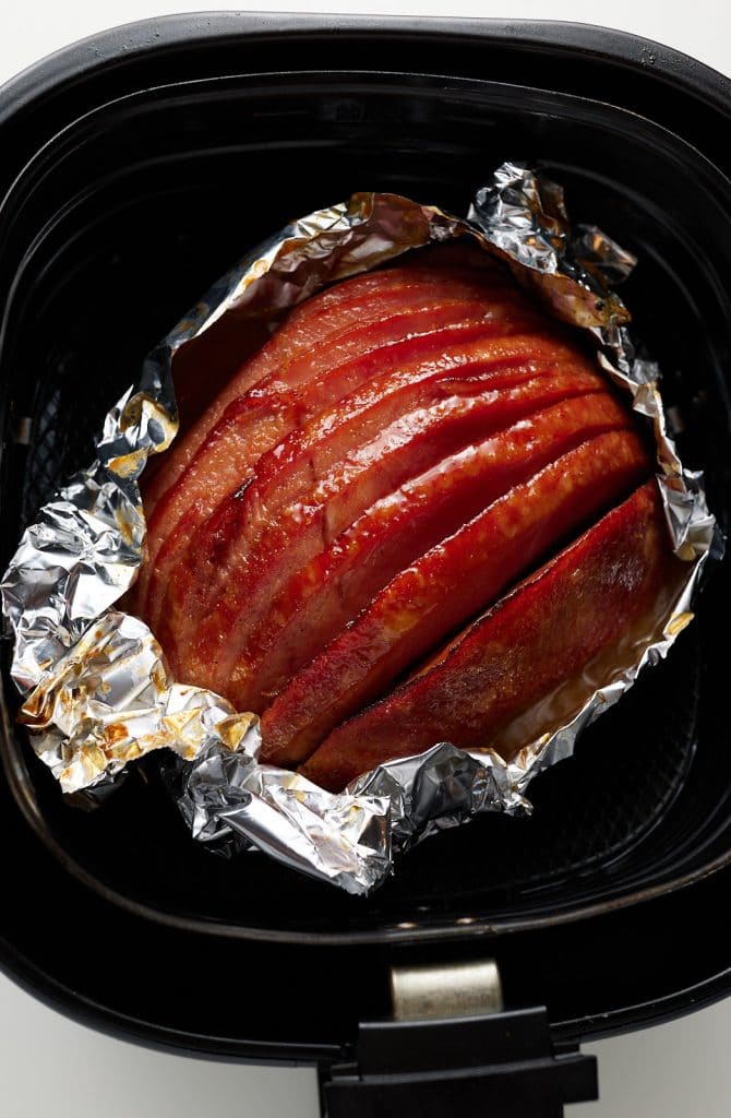 The cooked holiday ham in the air fryer basket.