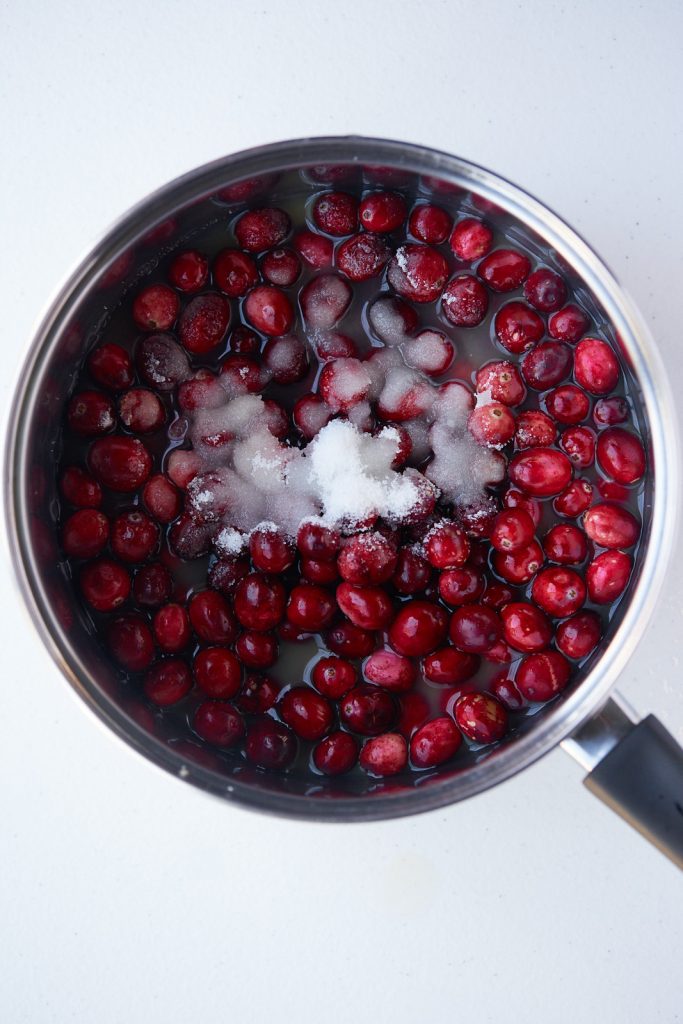 Sugar and cranberries in a pot before cooking.