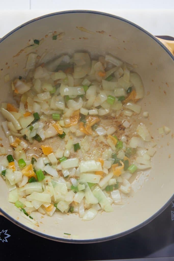 The onion and garlic being sautéed in a pot.