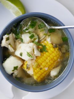 Fish soup in a blue bowl with a spoon.