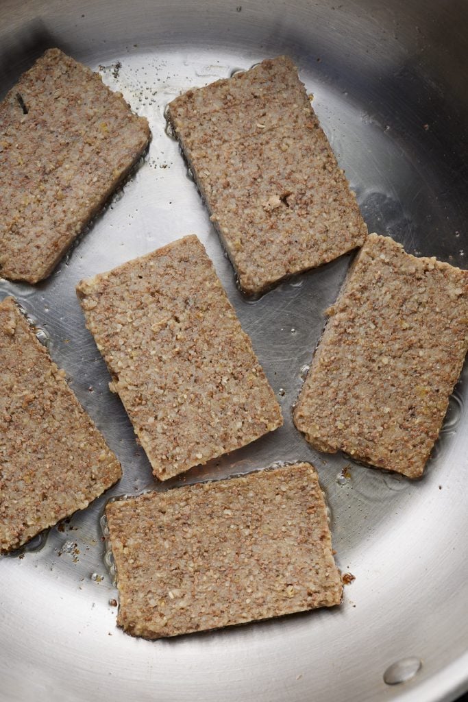 Slices of livermush in a skillet.