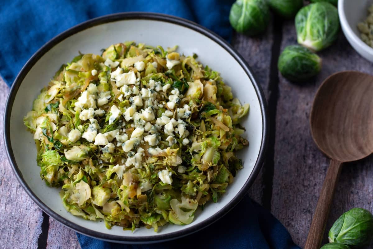 cooked shredded brussels sprouts with raw brusel sprouts on the side