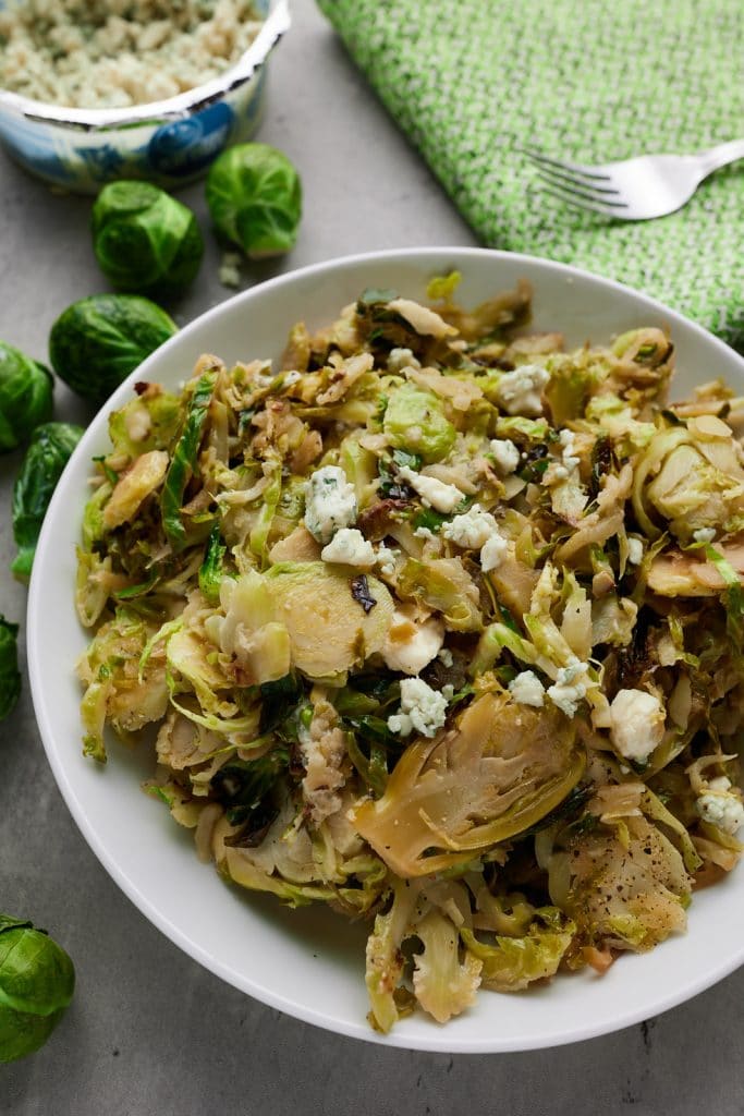 Sautéed Brussels sprouts served in a white bowl.