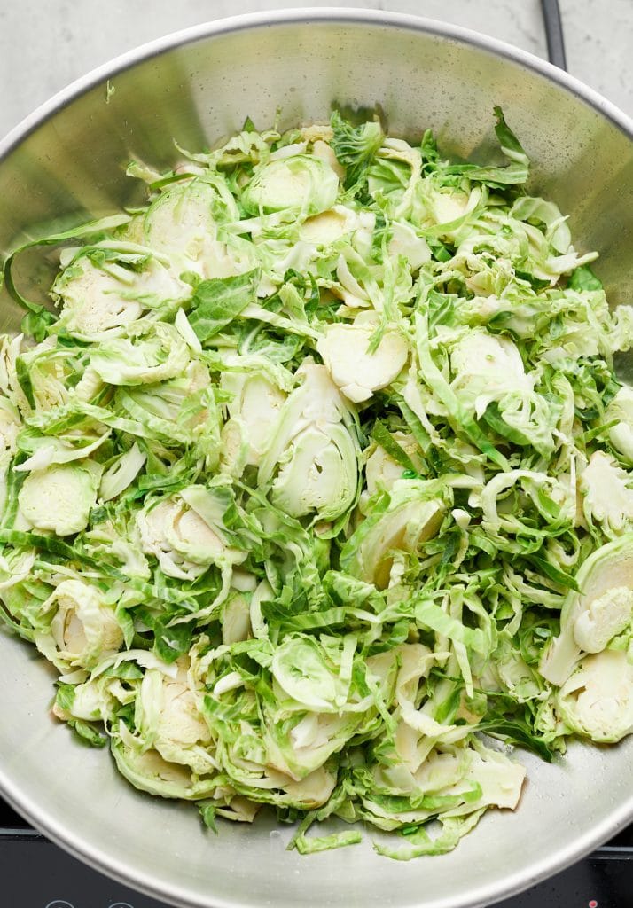 The raw Brussel sprouts in a skillet.