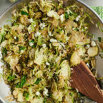 Stirring the shredded sprouts in a skillet.