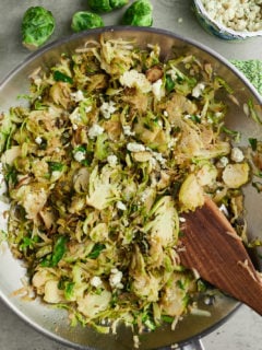 Stirring the shredded sprouts in a skillet.