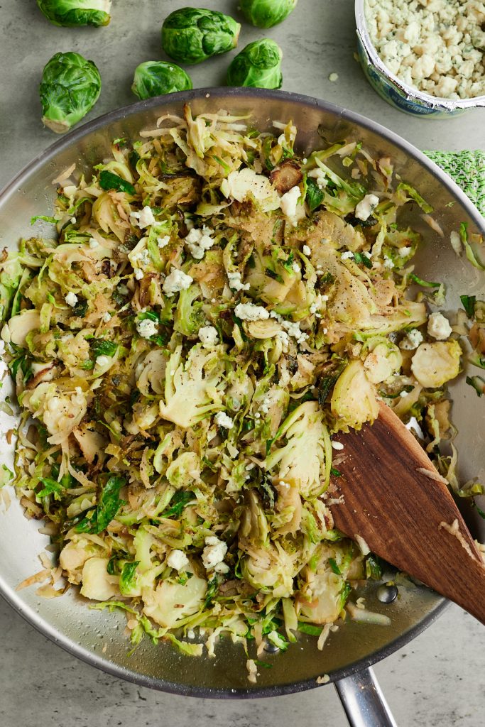 Stirring the shredded sprouts in a skillet.