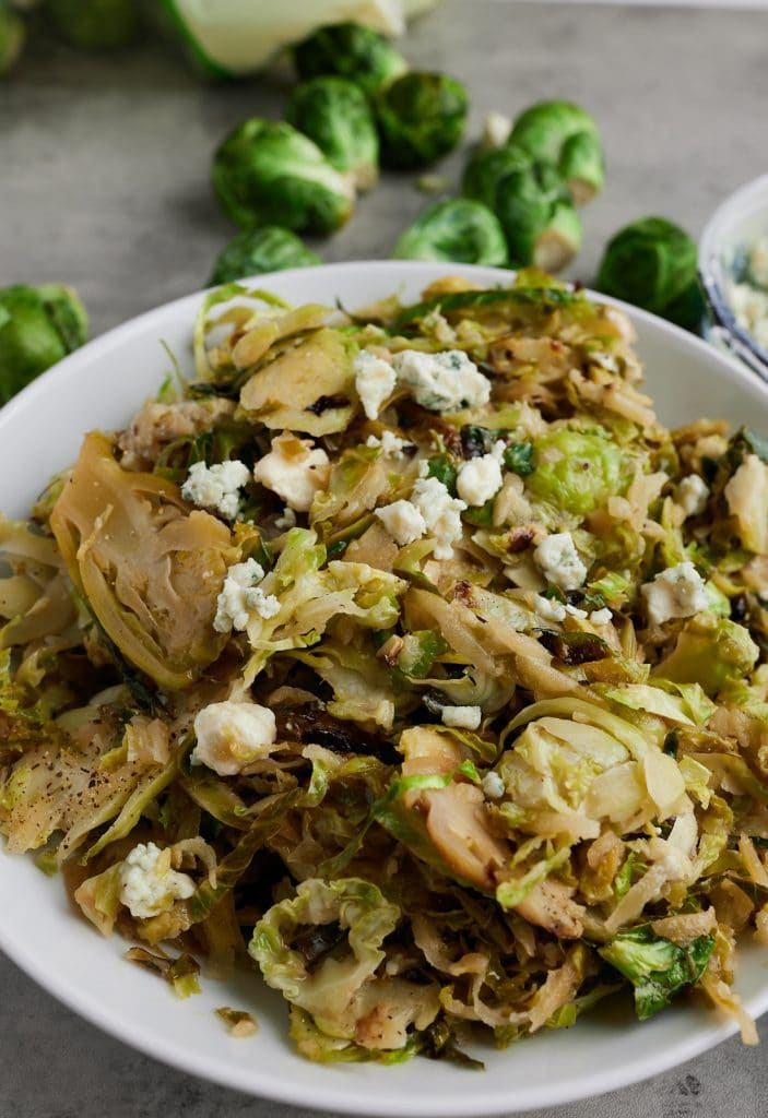 Cloe up of the cooked sprouts served in a white bowl.