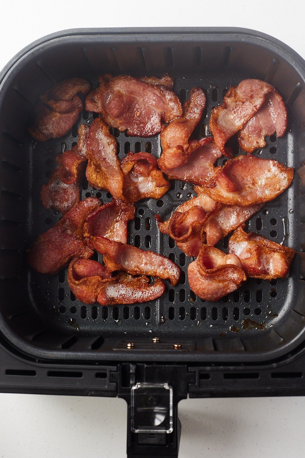 Overhead shot of the bacon cooked in the air fryer basket.