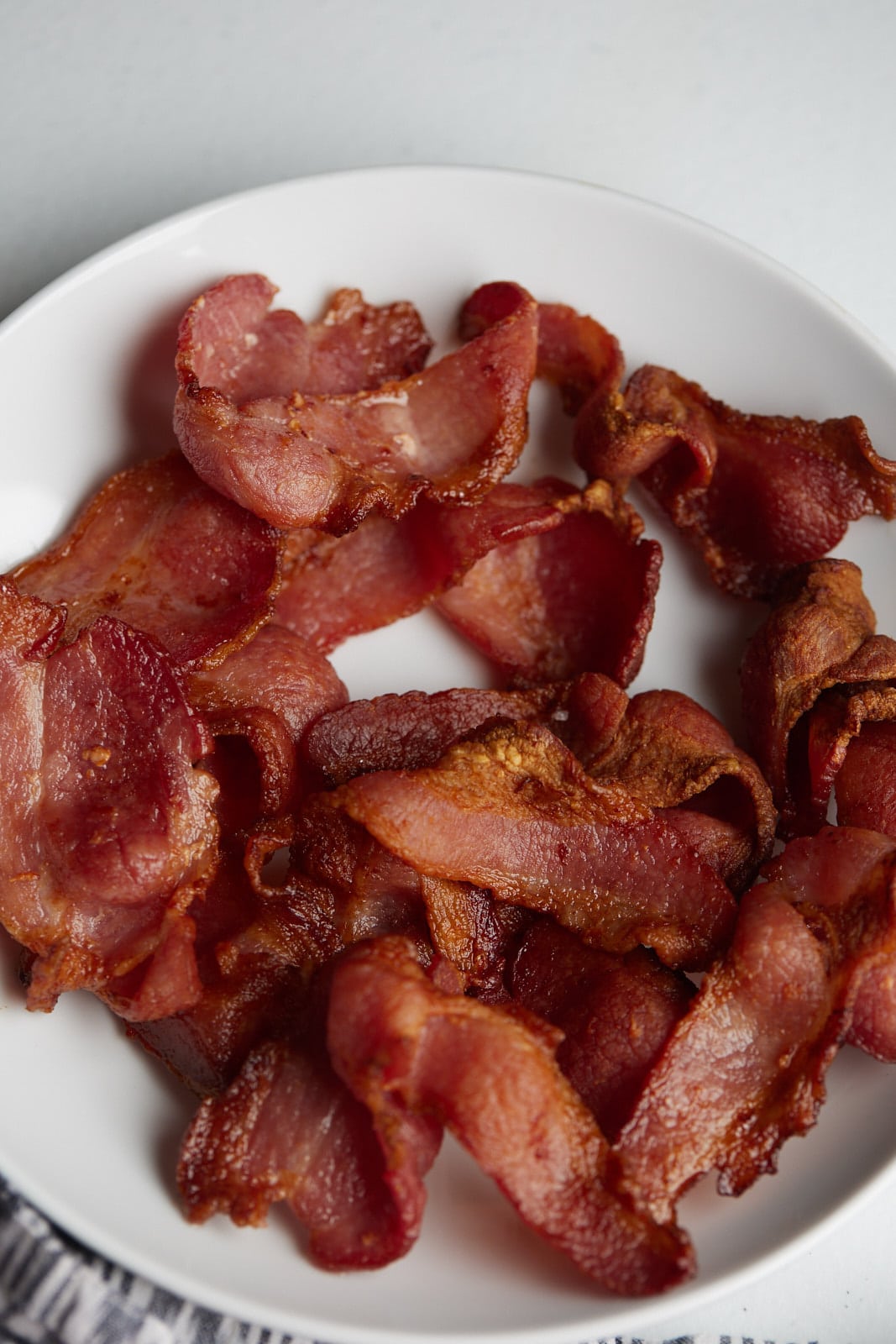 Air fryer bacon served on a white plate.