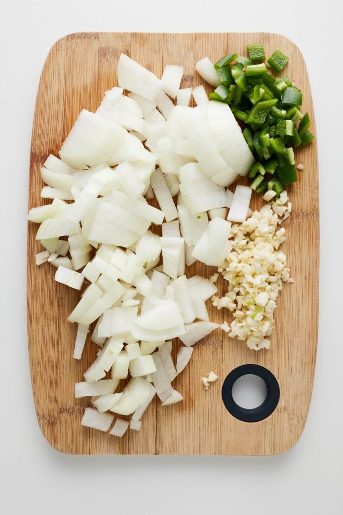 Chopped onions, garlic and jalapeno on a cutting board.