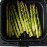 Asparagus in the air fryer basket ready to be cooked.
