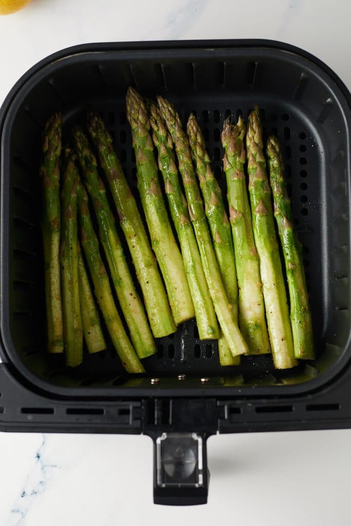 Asparagus in the air fryer basket ready to be cooked.