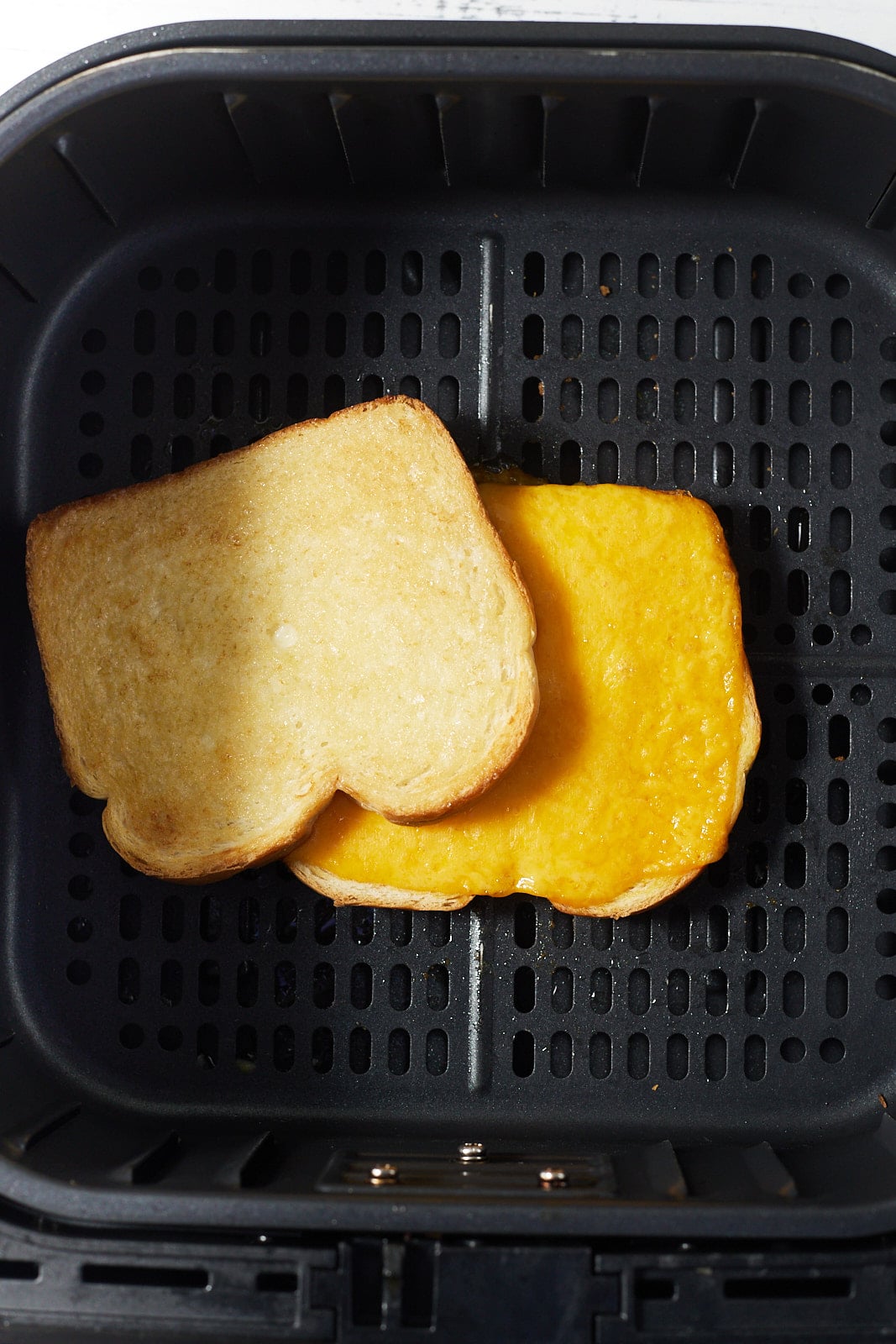 Once slice of bread on top of cheese on a piece of bread in an air fryer.