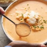 crab bisque in bowl with hands holding it