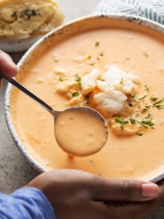 crab bisque in bowl with hands holding it