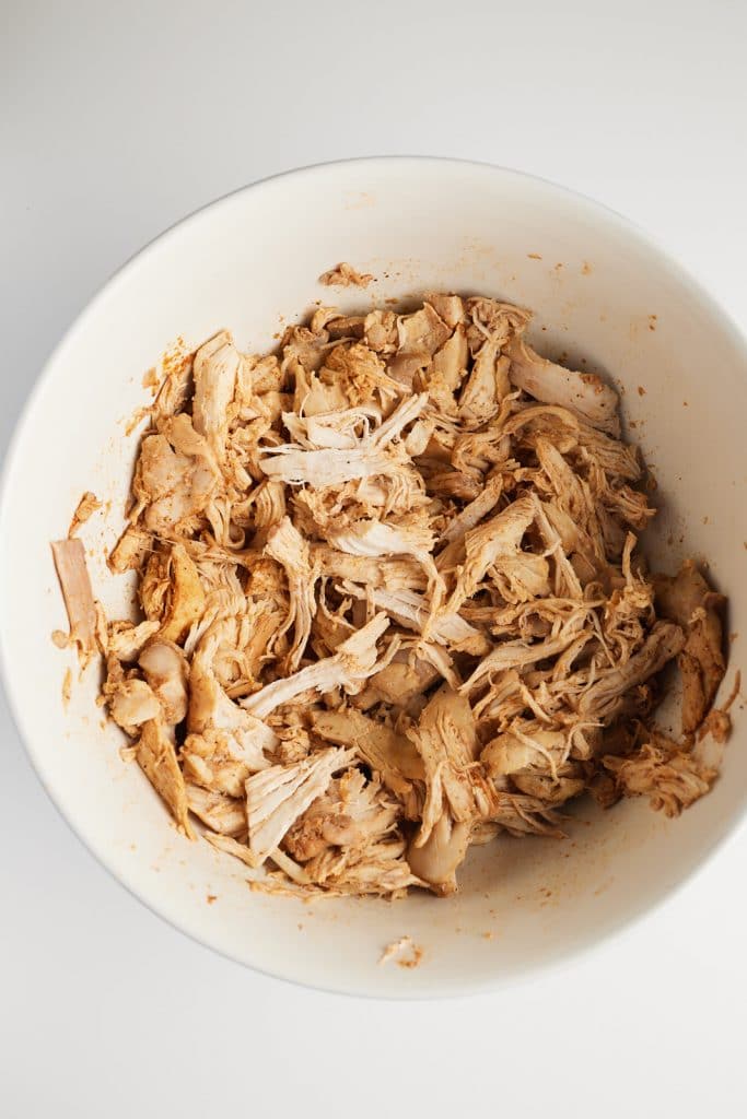 Shredded chicken in a white bowl.