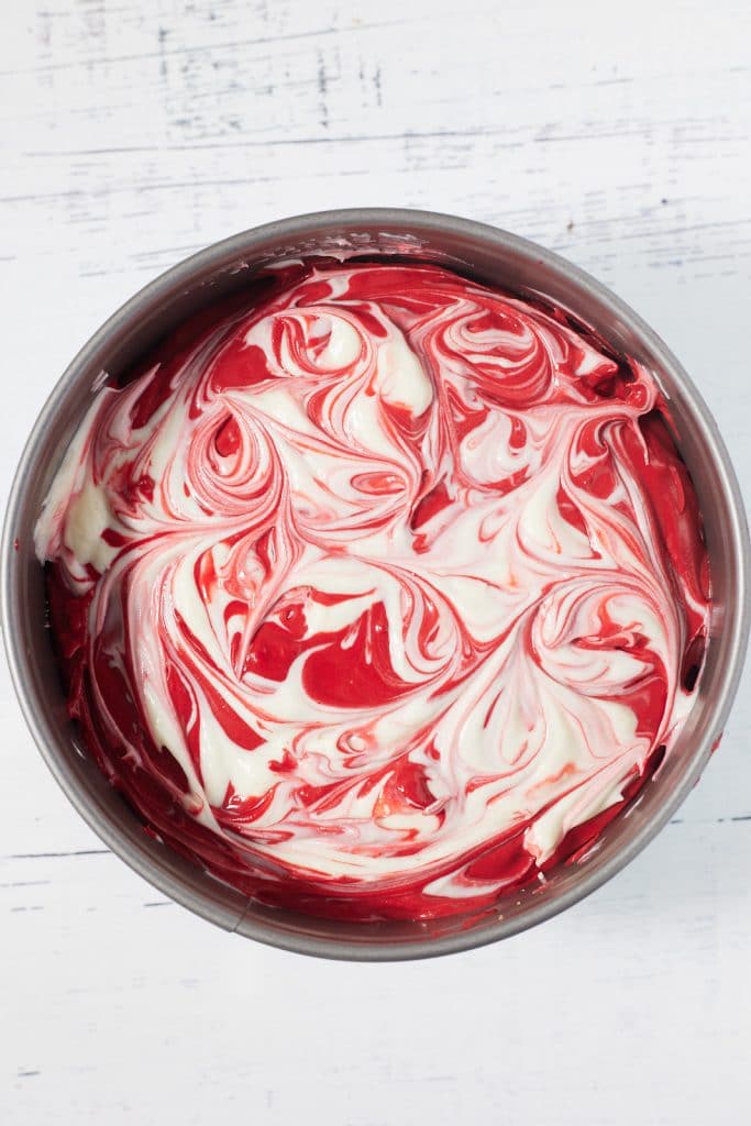 The white batter swirled into the red cake.