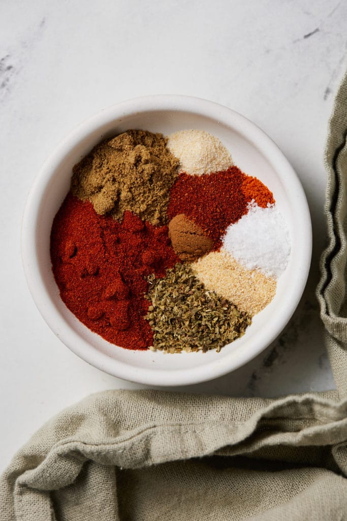 Spices and herbs in a white bowl.