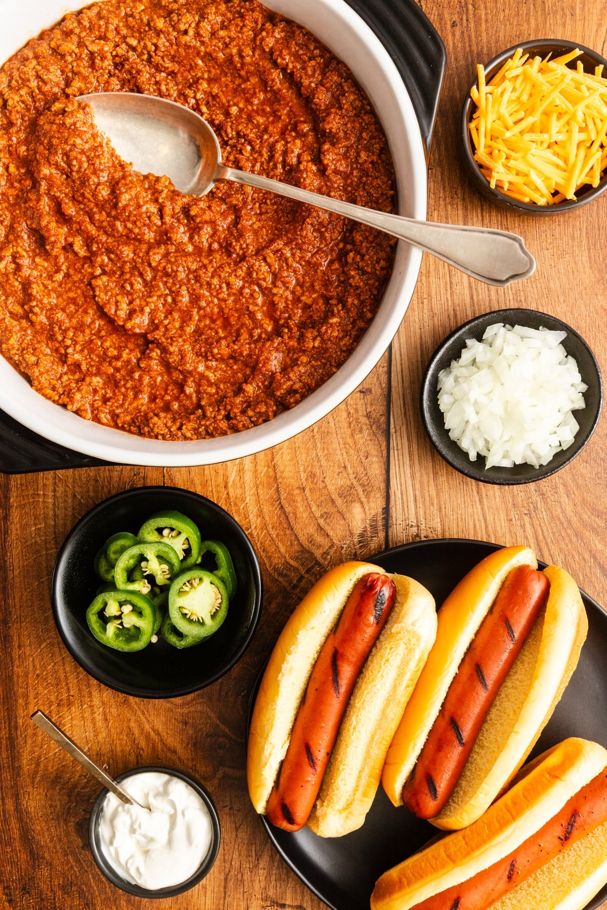 hot dog chili in pot with other ingredients surrounding it