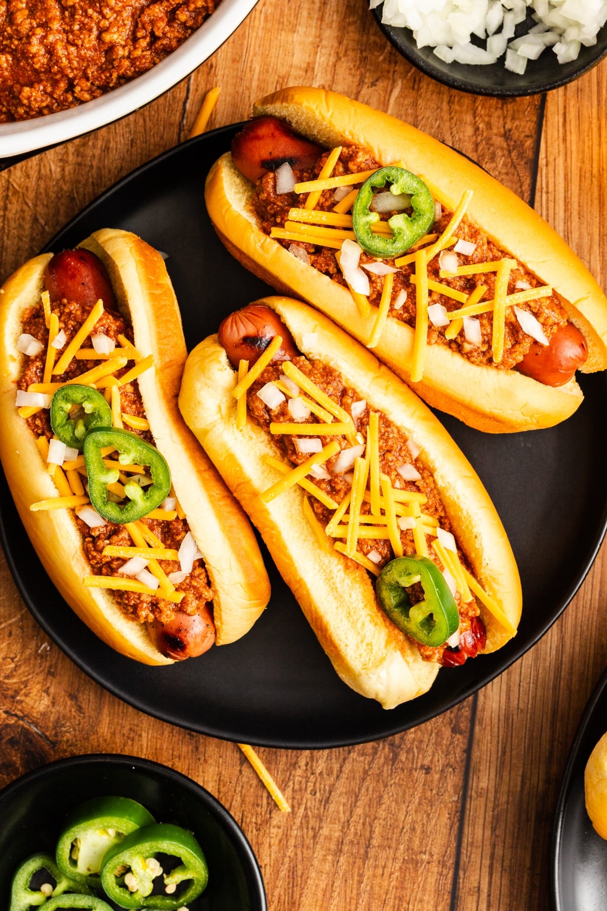 three hot dogs covered in whicli and toppings