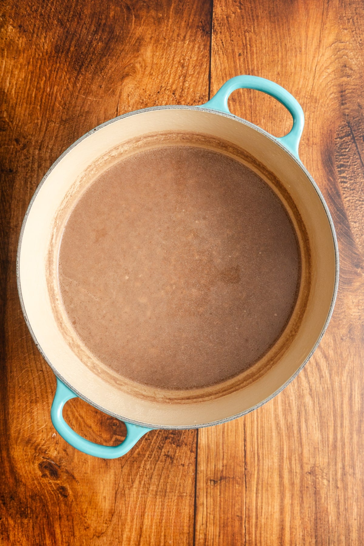 Beef in pot covered in water and browned