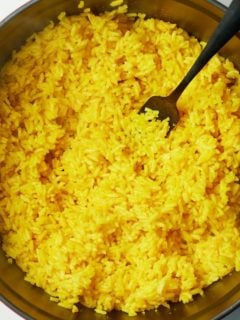 yellow rice in pot with fork sticking out
