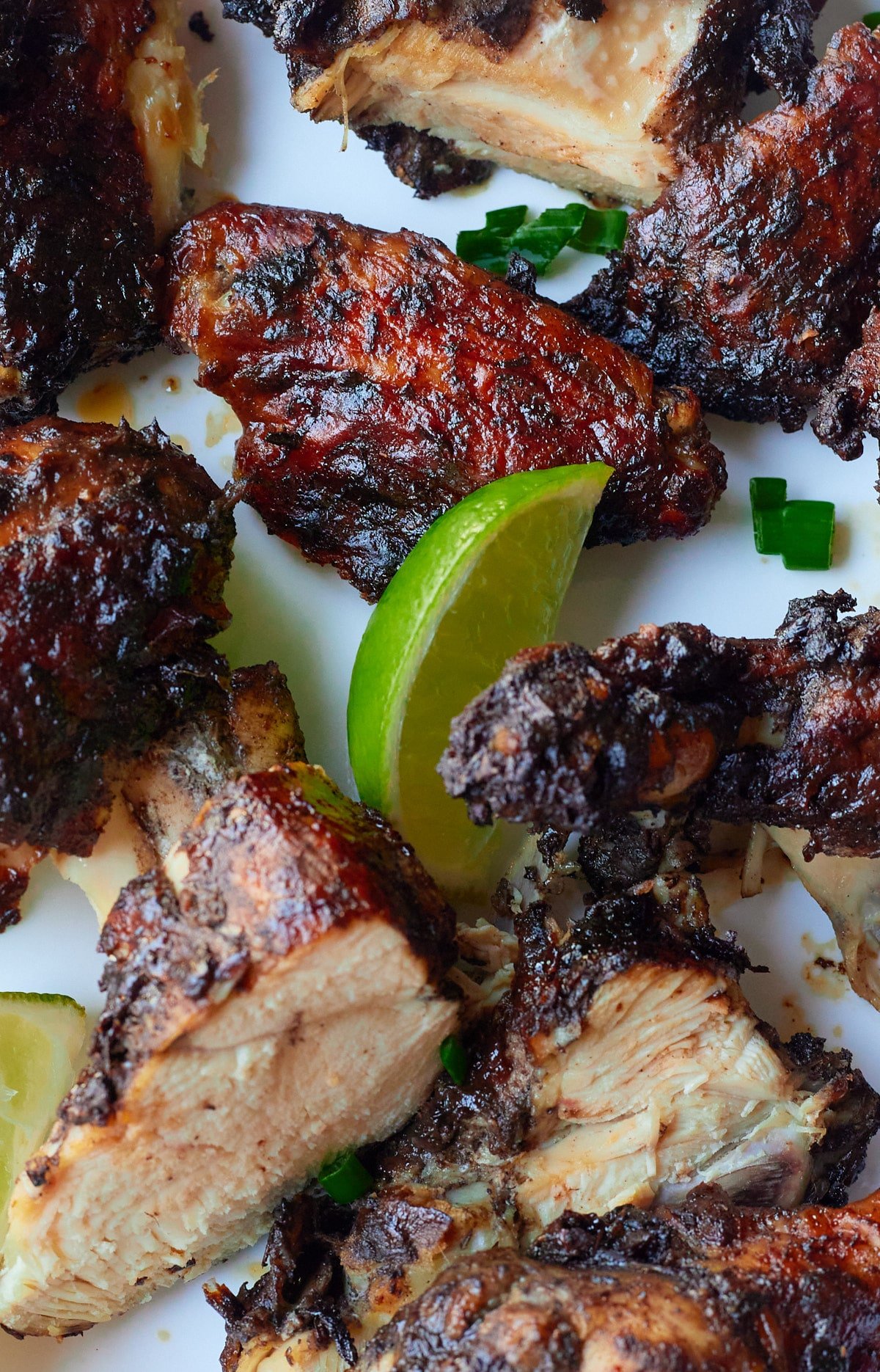 Close up of a lime wedge with pieces of marinated chicken.