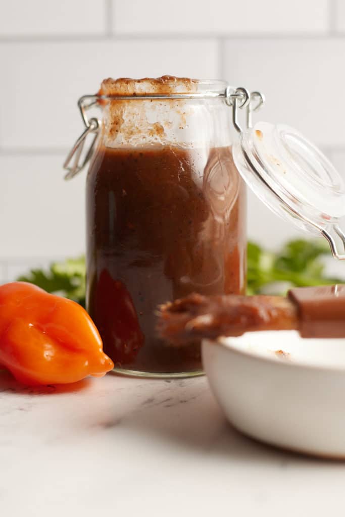 A jar of jerk bbq sauce on a basting brush.