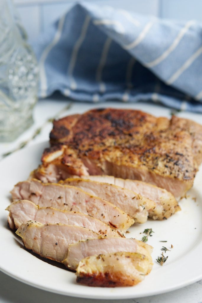 pork chops sliced in front of blue napkin