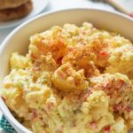 southern potato salad in bowl topped with paprika
