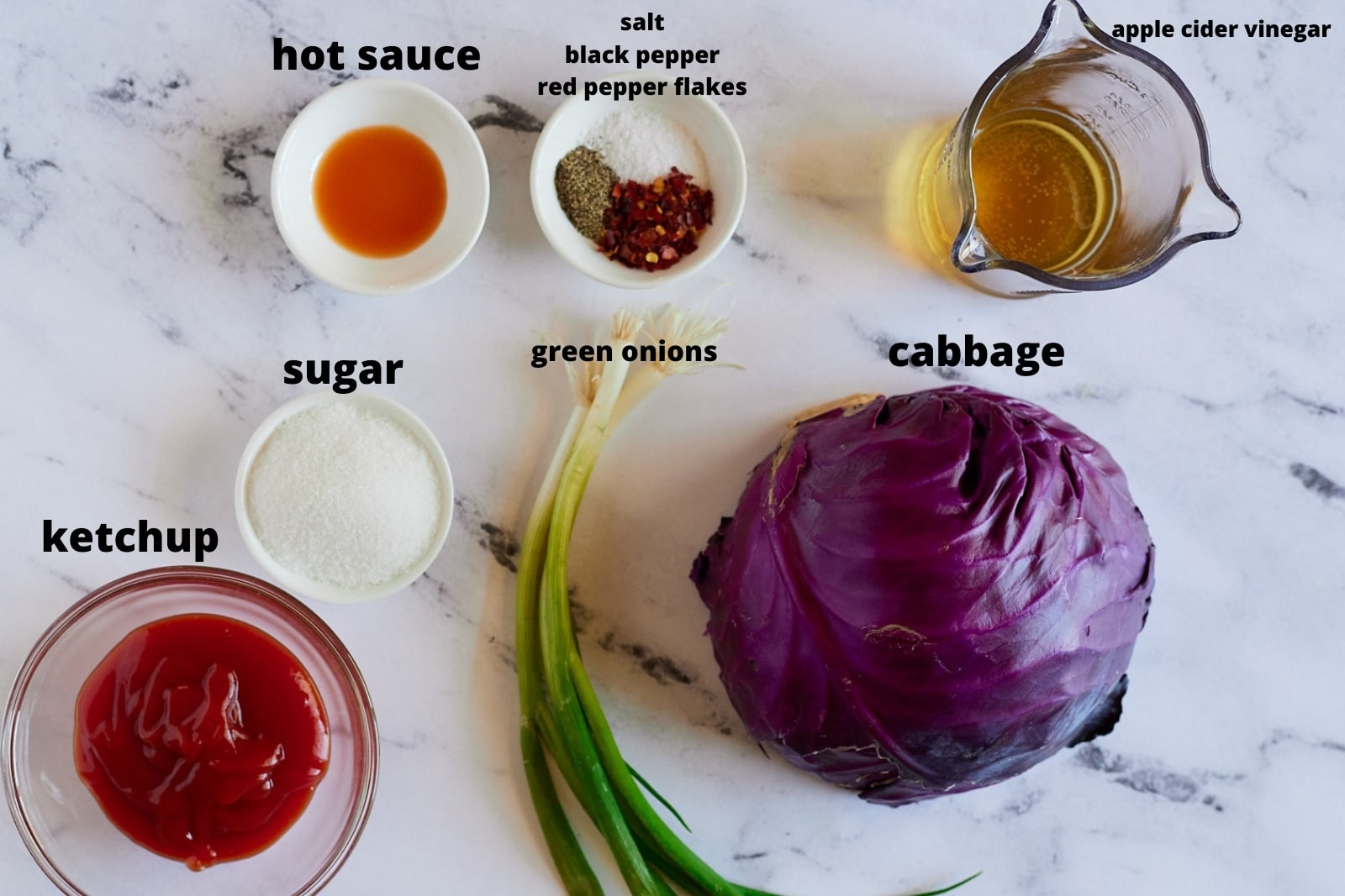 Ingredients for the vinegar coleslaw on a marble work surface.