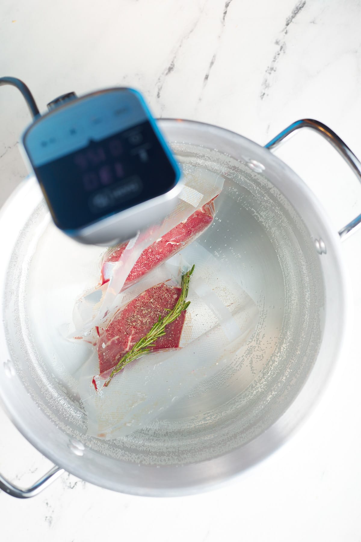 The filet mignon in a pot of water with a sous vide machine.