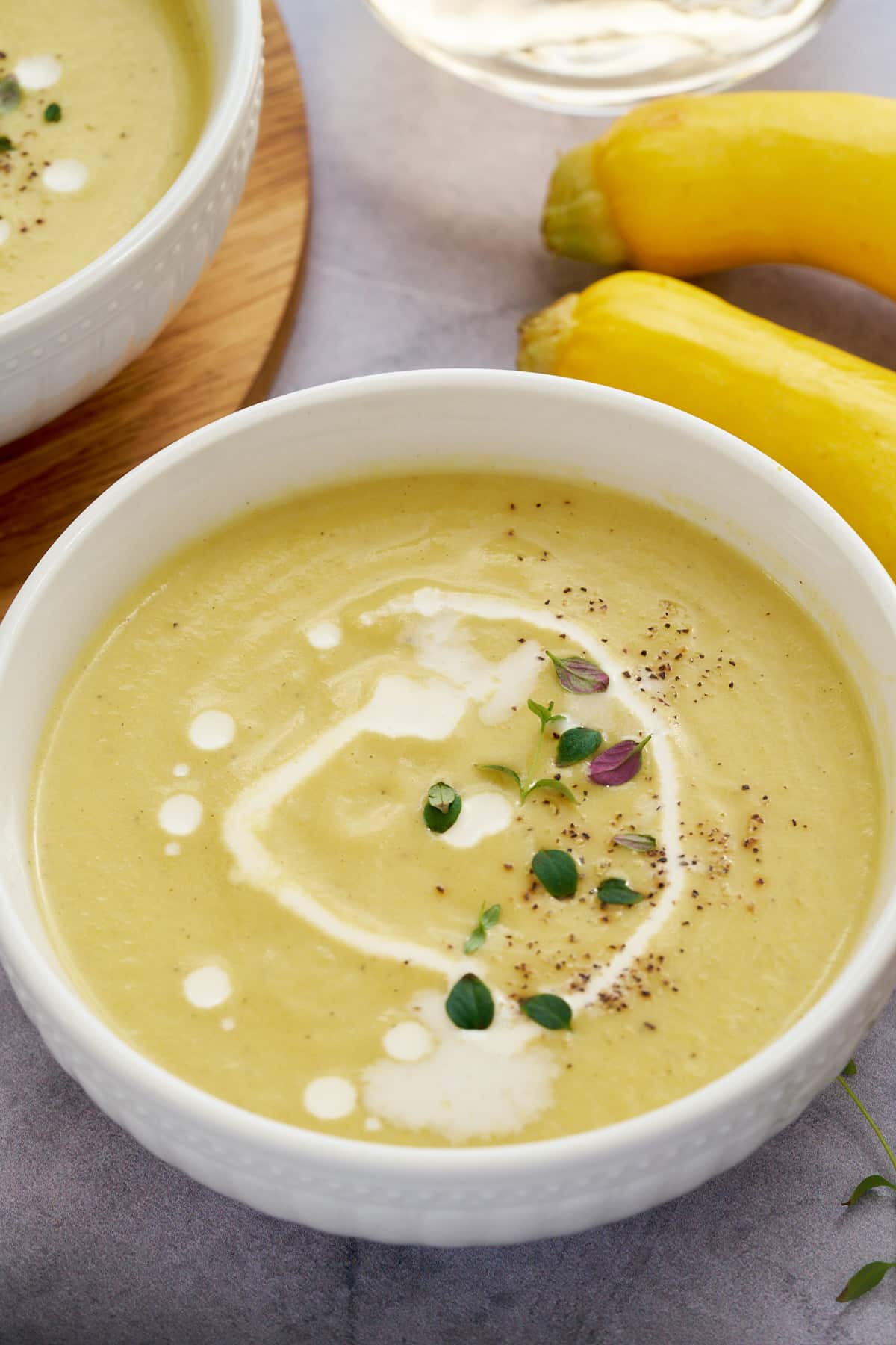 Yellow squash soup served in two white bowls.