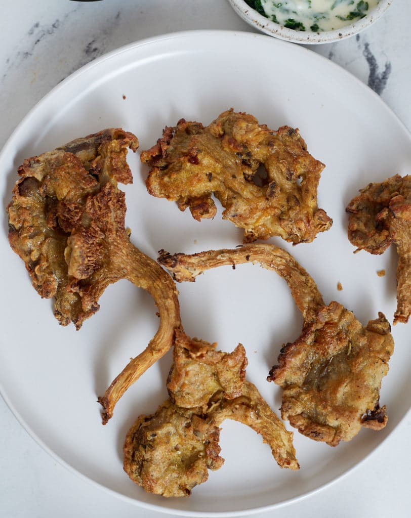 Air fryer fried mushrooms on a white plate.