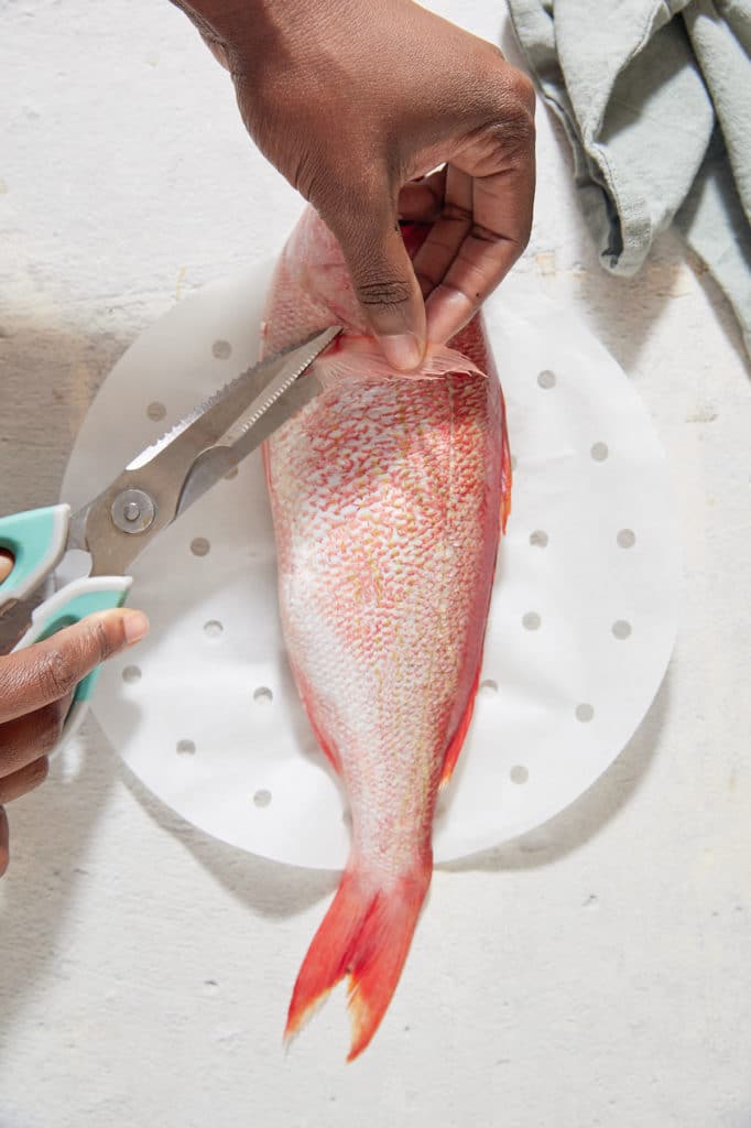 Cutting the fins off of the fish.