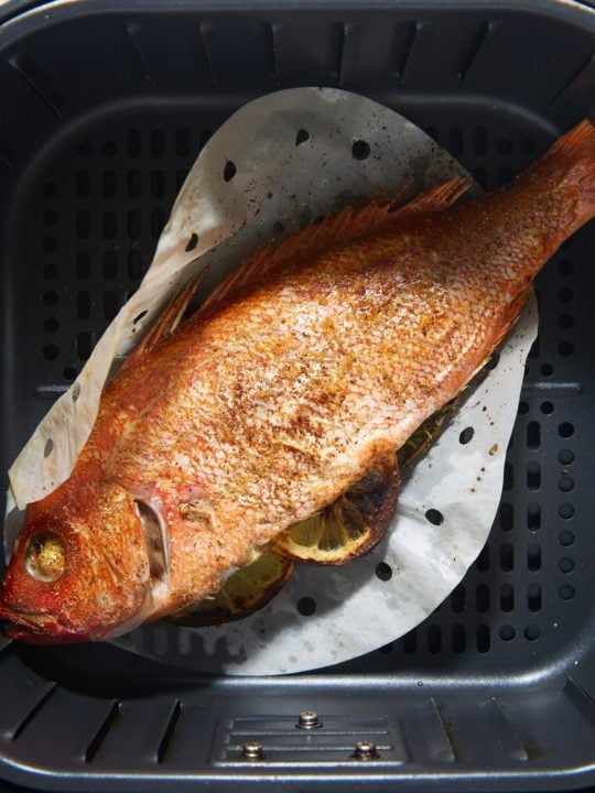 The cooked whole fish in the air fryer basket.