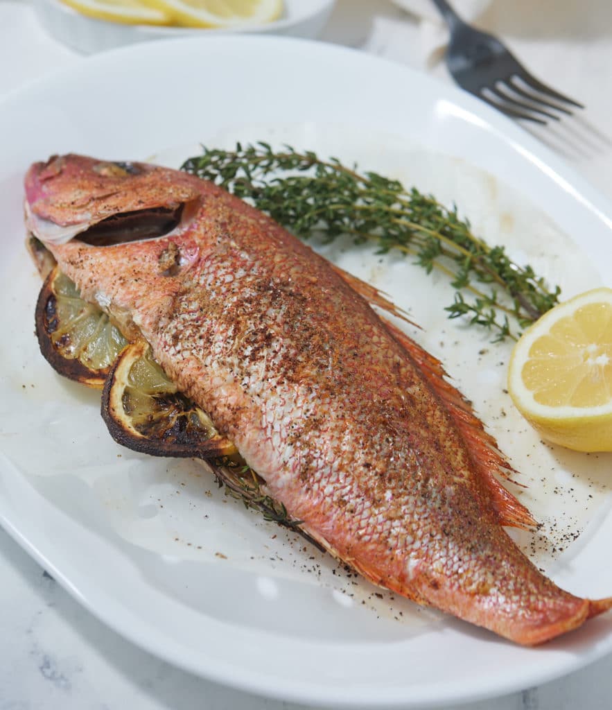 Air fryer whole fish served on a white plate.