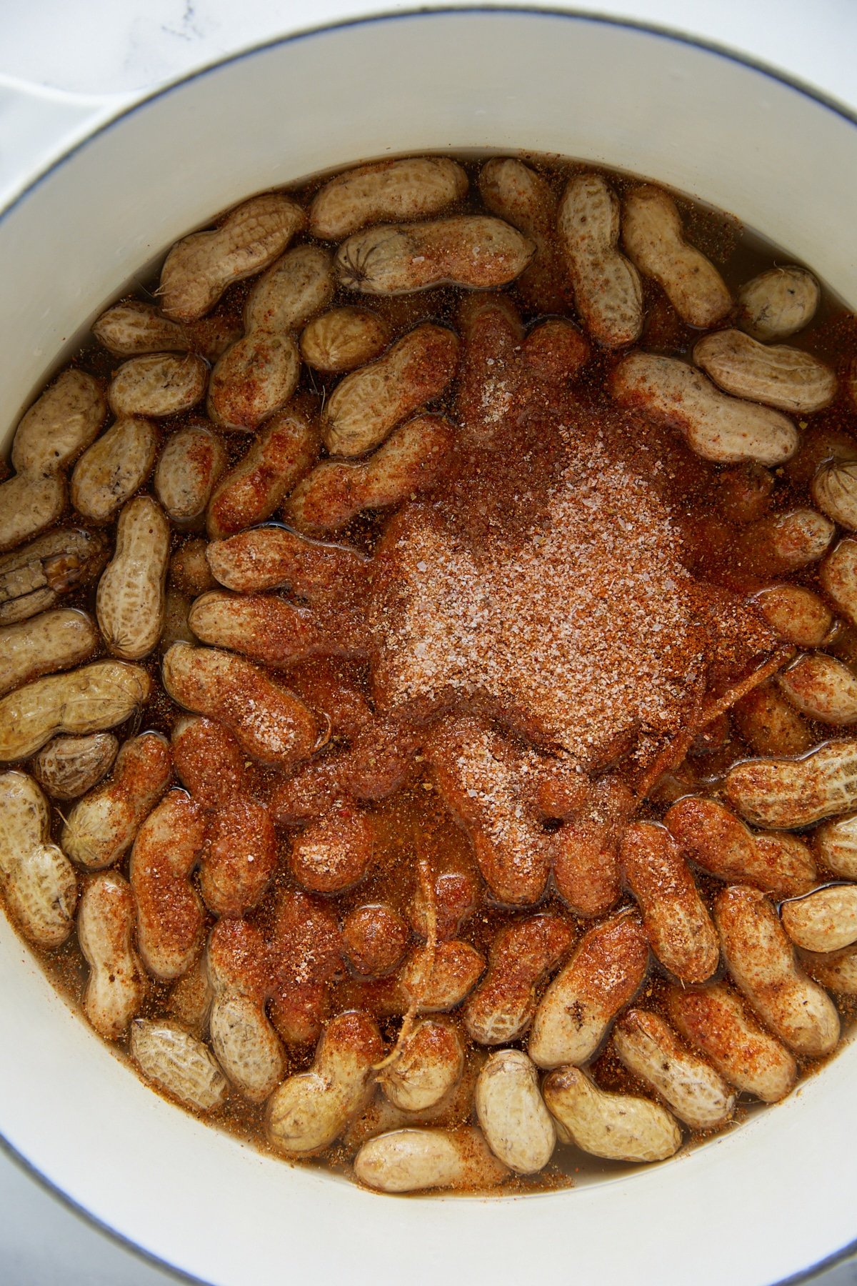 Seasonings added to the peanuts in a large pot.