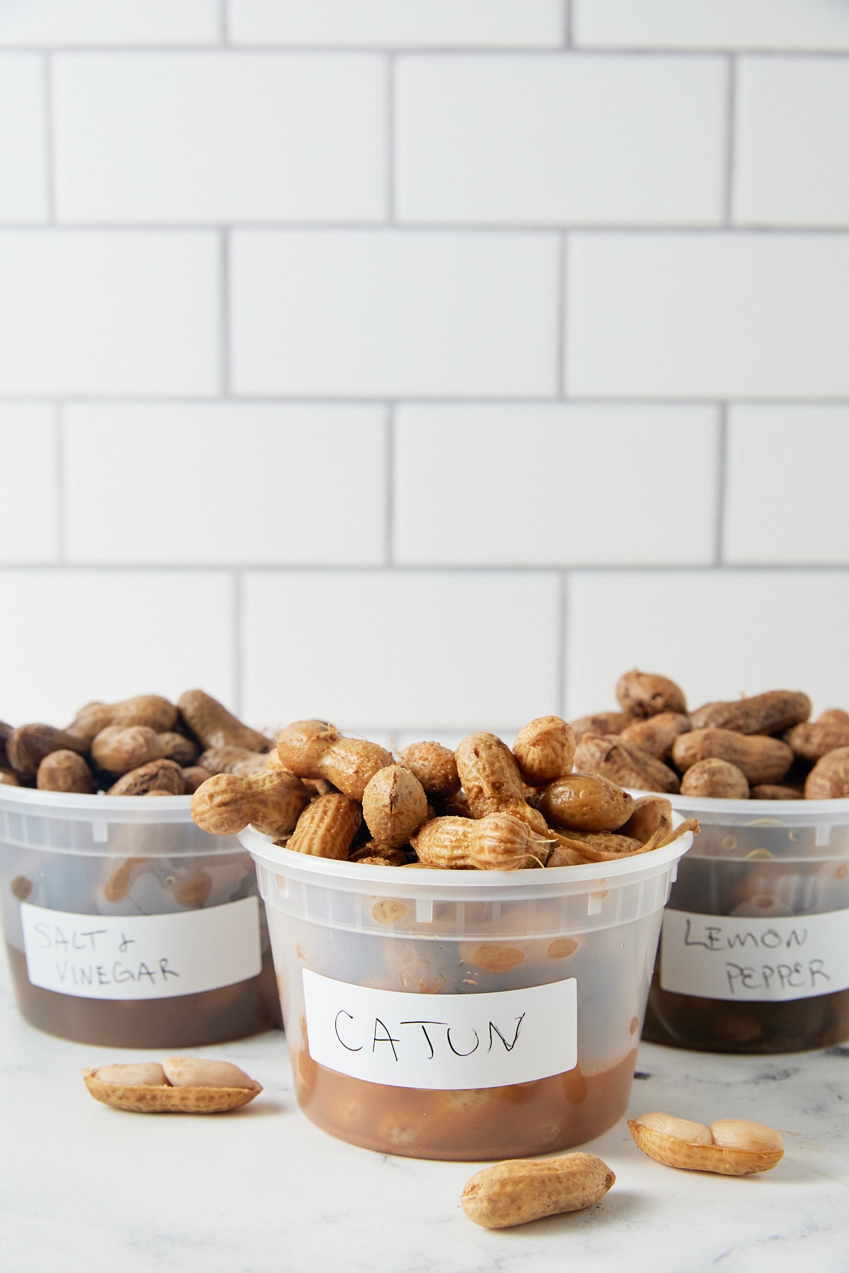 Three plastic cups filled with flavored boiled peanuts.