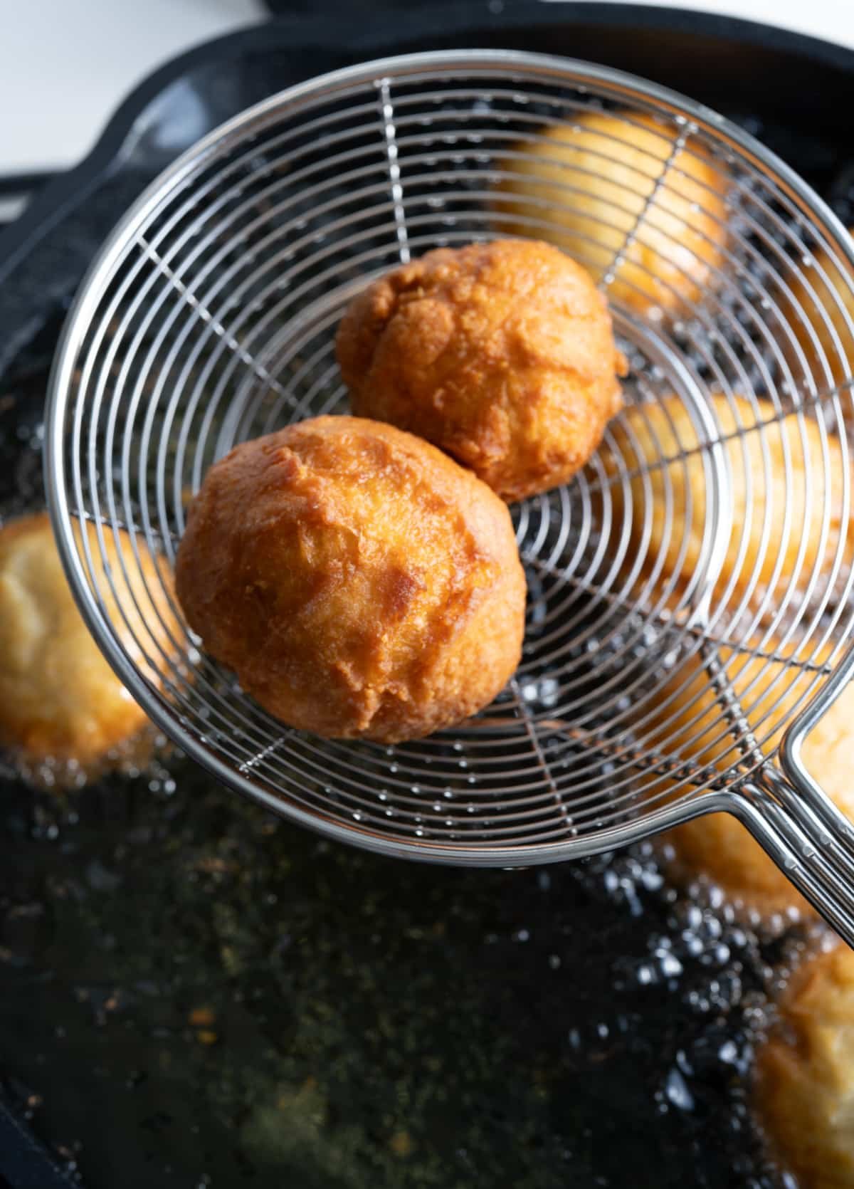 Dumplings being fried in oil. 