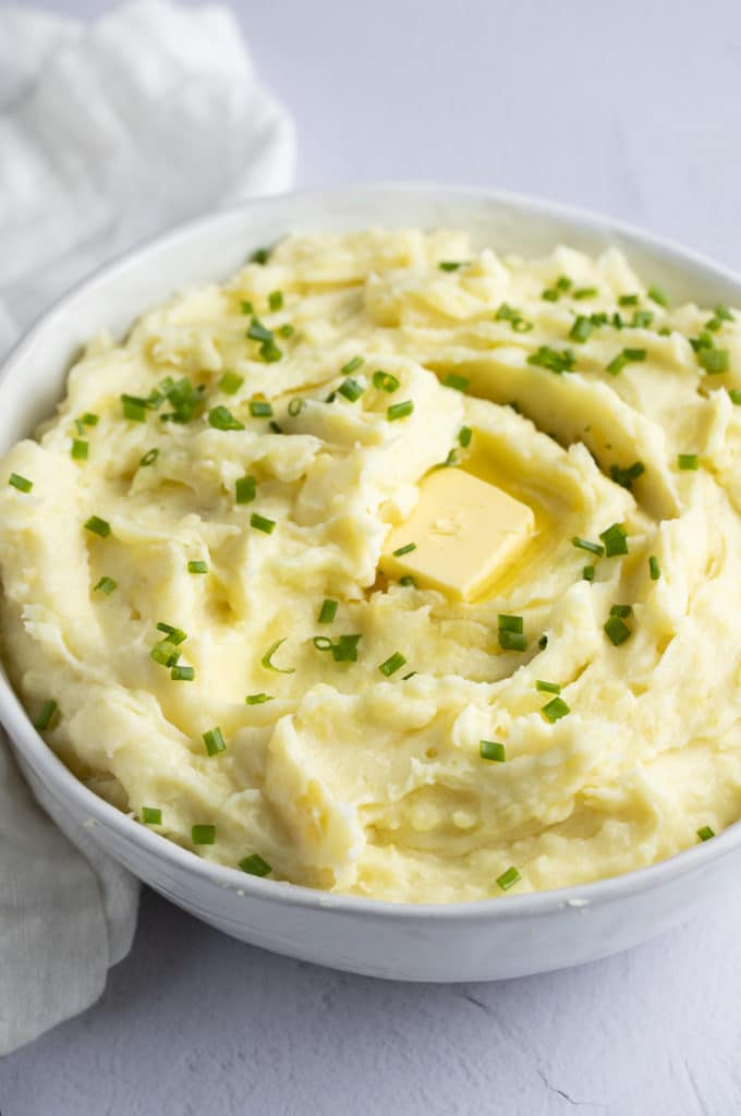 Garlic mashed potatoes in a bowl with a pat of butter.