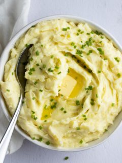 A pat of butter melting on top of the garlic mashed potatoes.