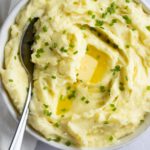 Garlic mashed potatoes in a bowl with a spoon.