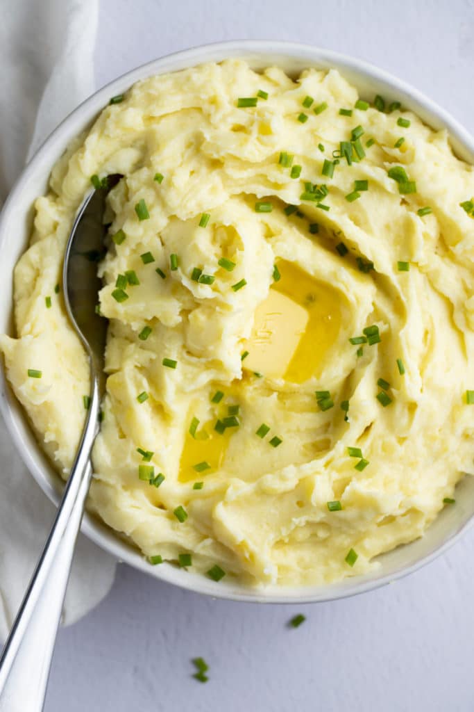 Garlic mashed potatoes in a bowl with a spoon.