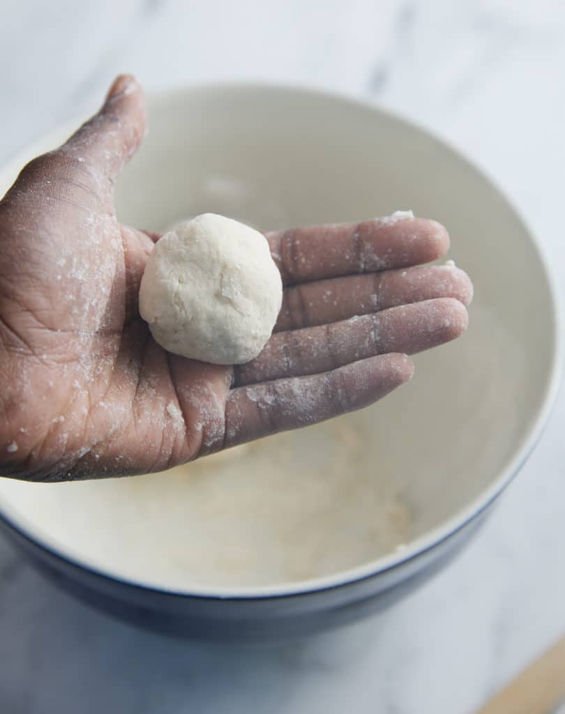 rolled raw dumpling in hand