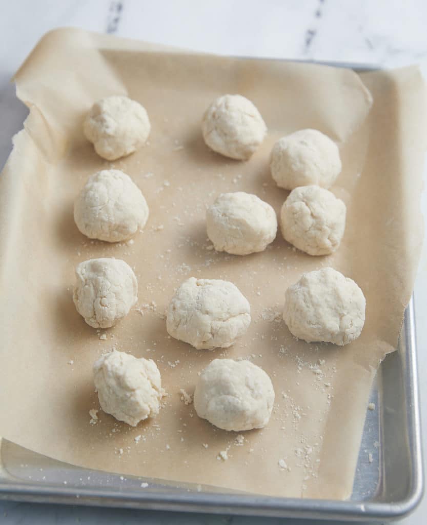 dumplings on parchment lined baking sheet